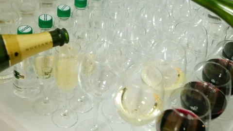 Waiter pours red wine in the rows of glasses at the festival. Media. On the Stock Footage 148078560