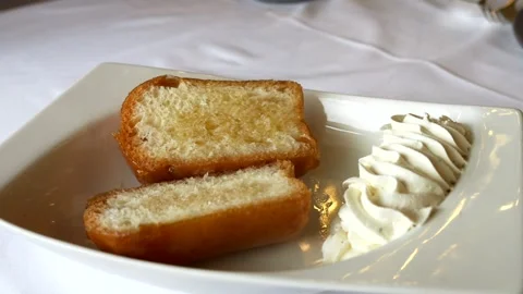 Waiter put Rum on baba split in two with cream on the side. Slow motion 4K Video stock 297752886