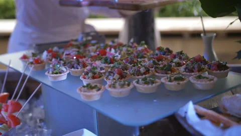 The waiter puts cold appetizers in the buffet area on the terrace of the Stock Footage 112621373