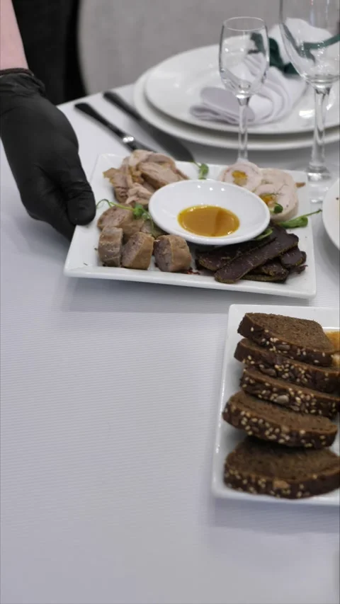 Waiter puts dish on table. festive table setting. luxury event organization Stock Footage 306885237
