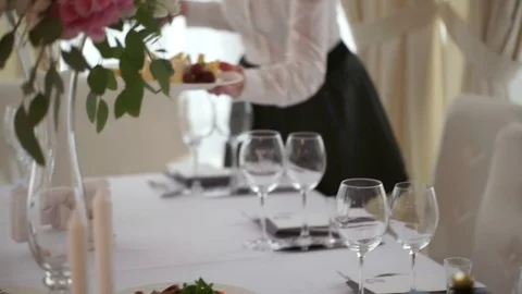 The waiter puts a plate of snacks on the wedding table close up Video stock 70754702