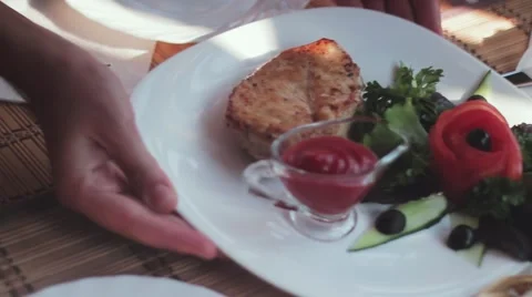 The waiter puts a plate with a stake on a table. Stock-Footage 52926726