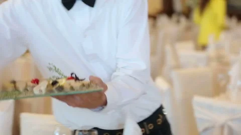 Waiter puts on a table a gourmet dish of stuffed fish Stock Footage 78777069