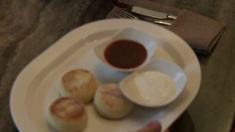 Waiter putting plate of chesecakes on the table Stock Footage 108604075