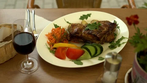 The waiter serves to customer. Meat dish from the chef in a summer restaurant. Stock Footage 101245629
