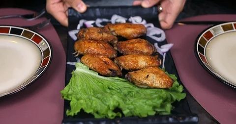 The Waiter serves dish on the Table. Chicken wings Stock Footage 119356196