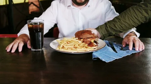 The waiter serves a man a large dish with fries and burger. Stock Footage 101750951