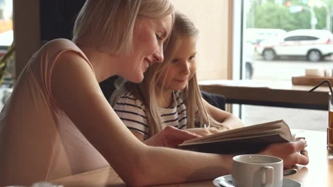 Waiter serves a refreshing drink to a delighted little girl at the cafe Stock-Footage 311944825