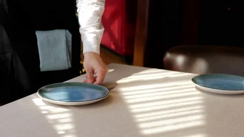 A waiter serves a table in an elite restaurant close-up. Men's hands arrange Stock Footage 172352173