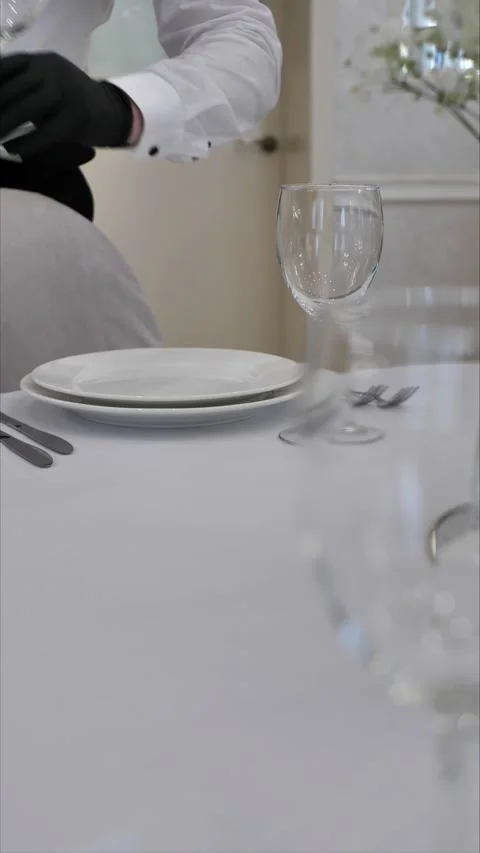 A waiter serves a table in a restaurant. sets a table in a restaurant. Glasses Stock Footage 306411169