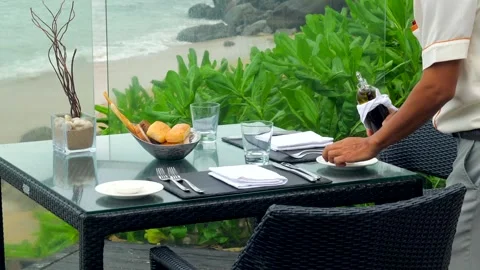 Waiter serves a table at a sea view restaurant Stock-Footage 242061045