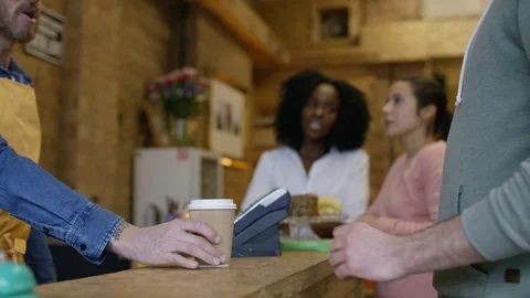 Waiter serving coffee and taking orders from customers at bike garage cafe Stock Footage 108034227