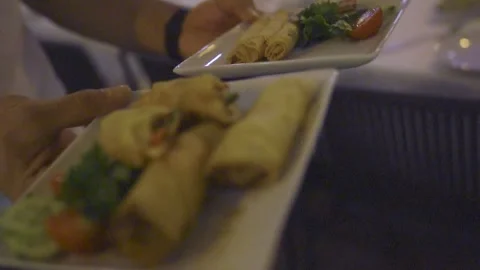 Waiter serving crispy spring rolls with salad garnish 스톡 동영상 332114521