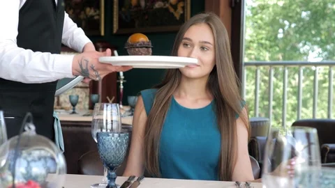A waiter serving a customer in a restaurant. Close-up of a waiter puts a plate Stock-Footage 156441439