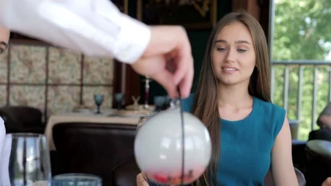 A waiter serving a customer in a restaurant. Close-up of a waiter putting a Stock Footage 172357605