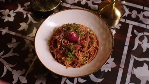Waiter serving delicious spaghetti bolognese in an elegant Arabic restaurant Stock Footage 345145895