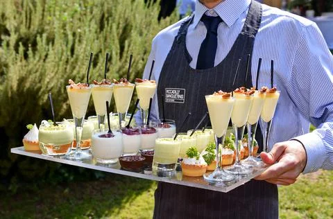 Waiter serving italian sweet dessert in glasses Stock Photos