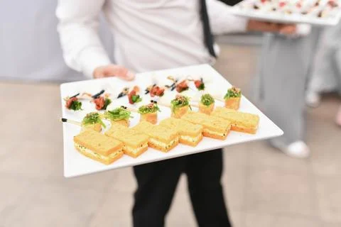 A waiter serving small appetizers at a wedding Stock Photos