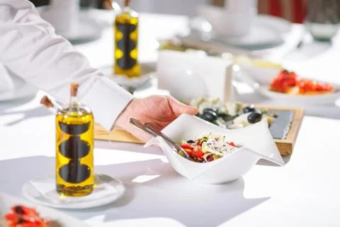 Waiter serving table in the restaurant preparing to receive guests. Stock Photos