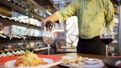 Waiter serving two glasses of wine in elegant restaurant Stock Footage 122112932