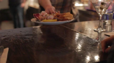 A waiter sets a dish in front of a customer in a restaurant Stock Footage 42428811