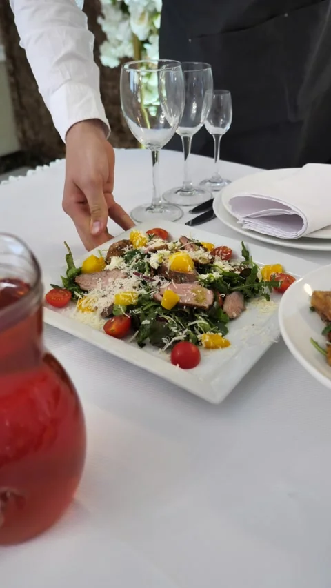 Waiter sets festive table with delicious dishes. festive table setting. Stock-Footage 315472384