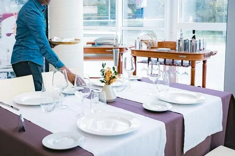 Waiter setting an elegant restaurant table Stock Photos