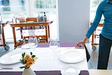 Waiter setting an elegant restaurant table Photos