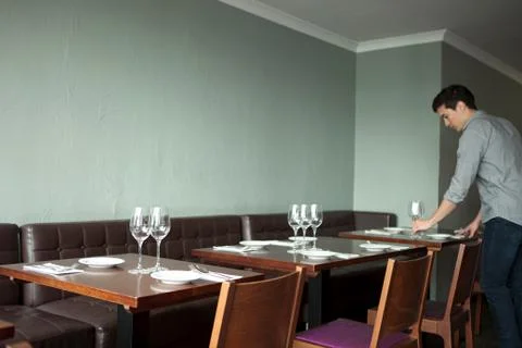 Waiter setting table in restaurant Stock Photos