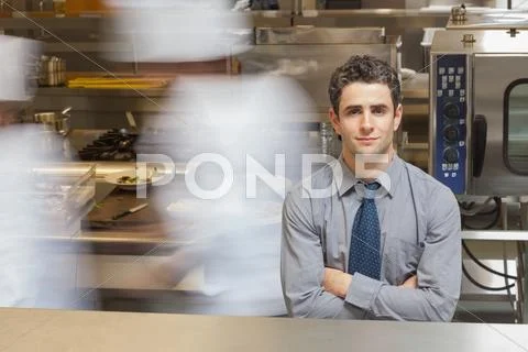 Waiter standing in busy kitchen Stock Photos