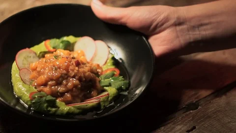 Waiter takes side dish in ceramic plate: fish tartar with vegetables and greens  Video stock 107777900