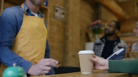 Waiter taking orders, accepting payment and serving coffee at bike garage cafe Stock Footage 108037136
