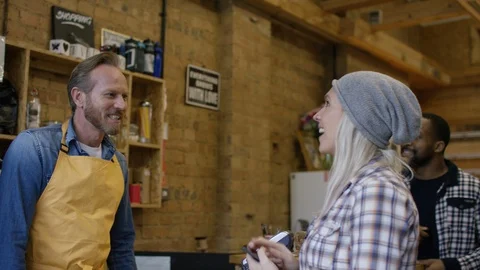 Waiter taking orders, accepting payment and serving coffee at bike garage cafe Stock Footage 108037240