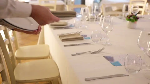 Waiter in uniform setting table in luxury restaurant for celebration party Stock-Footage 265610907