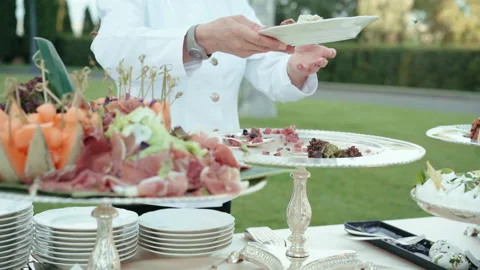Waiter in white uniform serving invited guests in the garden of beautiful luxury Stock Footage 225515296
