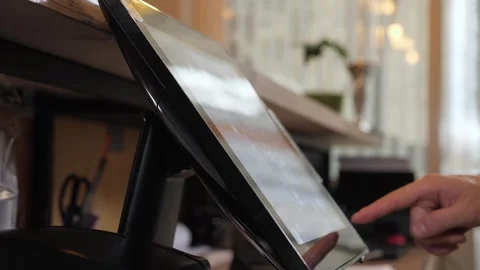 A waiter working at a computer in a cafe, he swipes a card through the terminal. Stock Footage 346442453