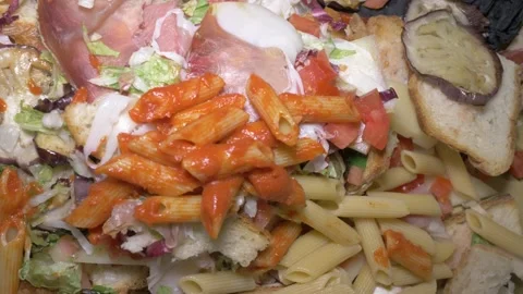 Waiters Emptying Plates of Leftover Food Into a Large Collection Bin Stock Footage 336793653