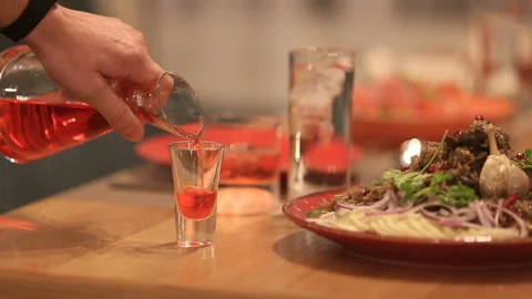 Waiter's hand pouring red beverage into a glass Stock Footage 144510587