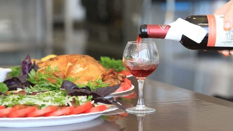 Waiter's hand pouring red wine into a glass Stock Footage 144510392