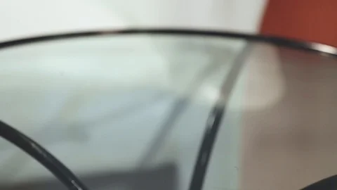 Waiter's hand puts a bone on a white plate for a small dog on a glass table Stockbeeldmateriaal 114509420