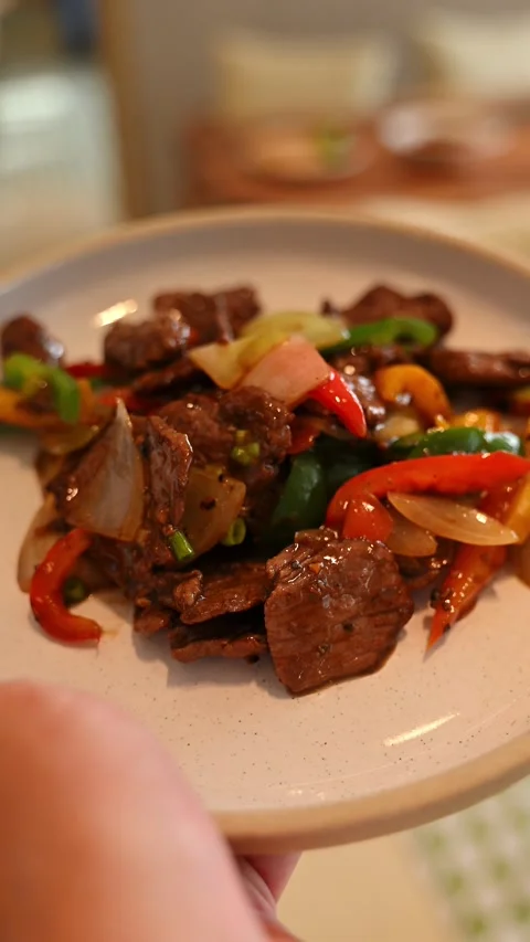 Waiter's hand reaching up to carry a freshly prepared plate of beef stir-fr.. Stock-Footage 338053176
