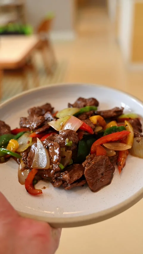 Waiter's hand reaching up to carry a freshly prepared plate of beef stir-fr.. Stock-Footage 338053201