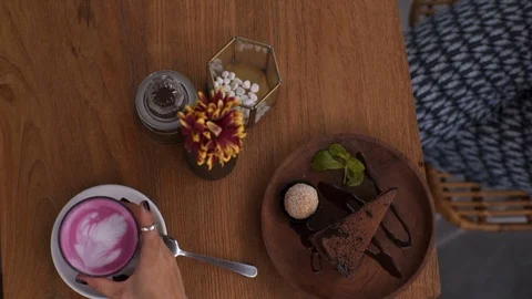 Waiter's hands put beetroot latte on the table Stock Footage 101633642