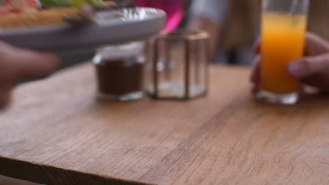 Waiter's hands put on the table waffles with cream and strawberrie Video stock 101634986