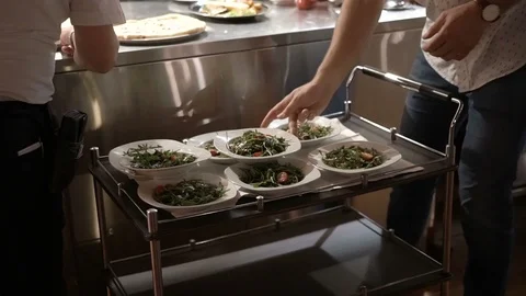 Waiters lay the dishes on the catering table Stock Footage 98309727