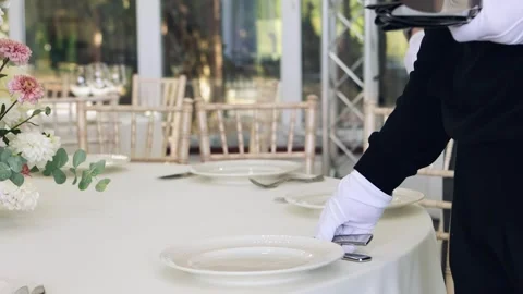 Waiters lay out cutlery on the table, preparing for the wedding banquet Stock Footage 260880142