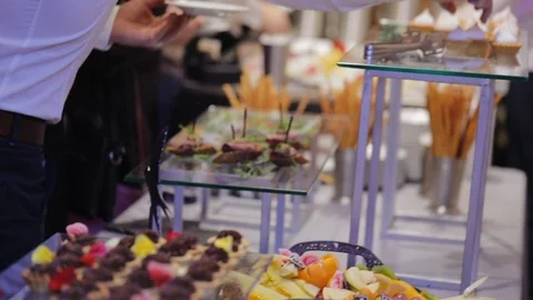 Waiters put luxury snacks with red caviar from tray on wedding table 動画素材 122060118
