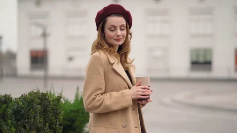 Waiting dancing with her shoulders beautiful girl in red beret and stylish beige Stock Footage 147119193