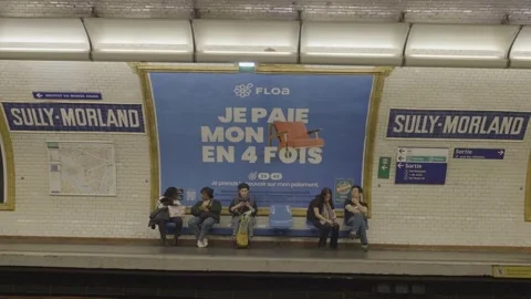 Waiting at Paris metro platform with advertisement promoting payment in four Stock Footage 305473821