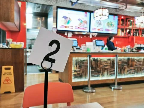Waiting queue card stands on a table in local cozy Chinese restaurant at nigh Stock Photos
